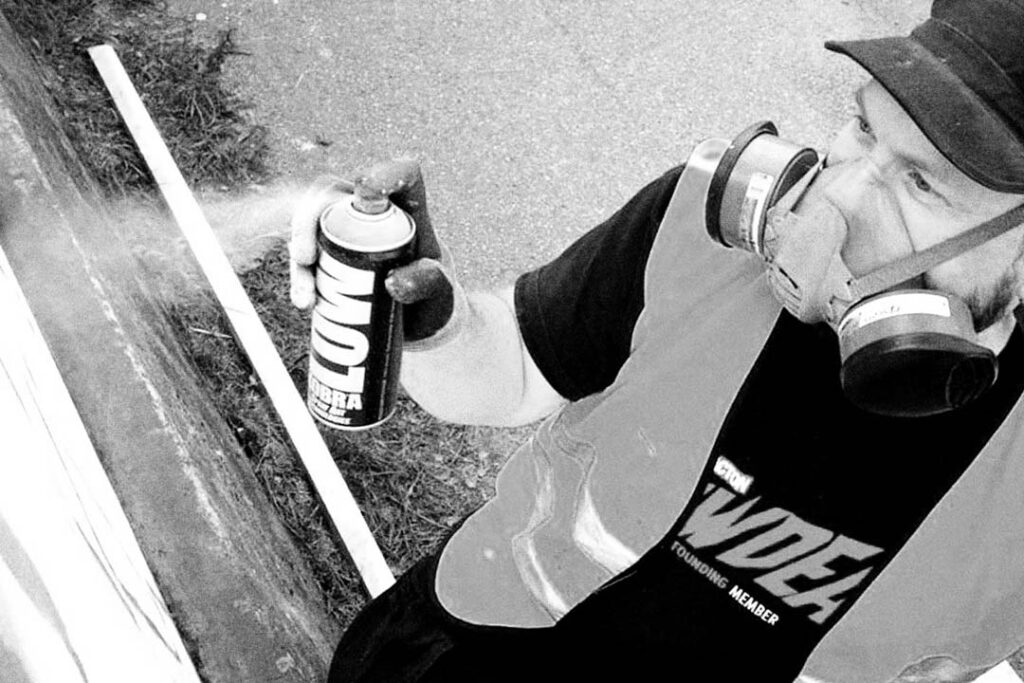 Person spraypainting a wall.